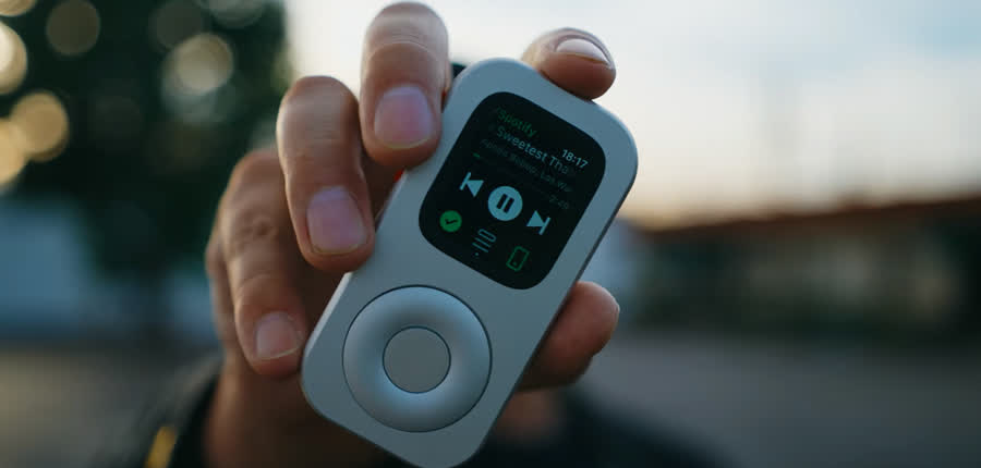 Front view of RePod C1 held outdoors with a music app visible on Apple Watch