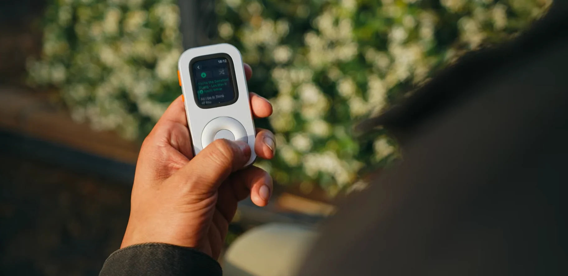 A person holding RePod outdoors before a 30-minute walk with the phone put away
