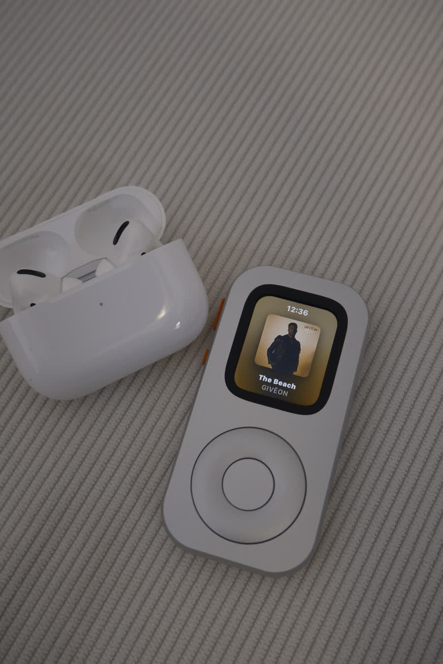 RePod C1 and AirPods arranged together with album artwork visible on the Apple Watch
